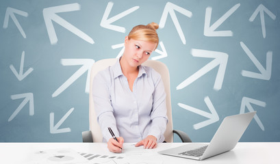 Business person sitting at desk with different direction concept