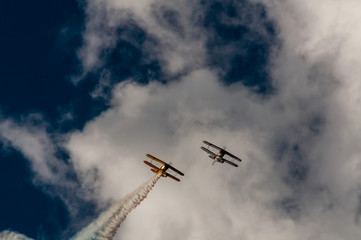 Fototapeta na wymiar Aerobatics planes flying in the sky with clouds in the background