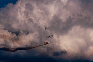 Aerobatics planes flying in the sky with clouds in the background
