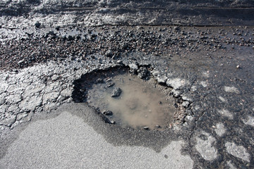 pothole damage on road after winter