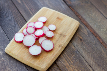 Obraz na płótnie Canvas sliced pieces of fresh radish on a cutting board