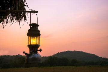 old Lantern hang a wood in sunset period.