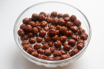 breakfast cereal with milk in a glass cup isolated on white background close up