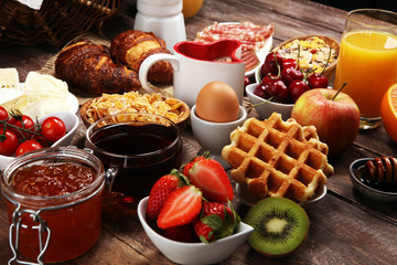 Breakfast served with coffee, orange juice, croissants and strawberry, jam and tea. breakfast table