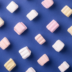 Sweet marshmallows on blue background. Minimalism concept