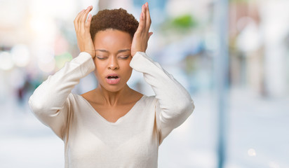 Obraz premium Young african american woman over isolated background suffering from headache desperate and stressed because pain and migraine. Hands on head.