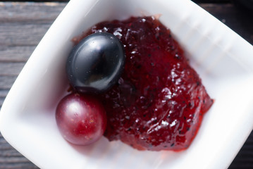 grape jelly and red grapes on black wood table