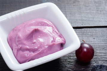 cosmetic cream from red grapes on black wooden