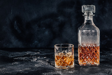Glass of the whiskey with a square decanter