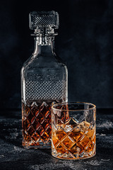 Glass of the whiskey with a square decanter