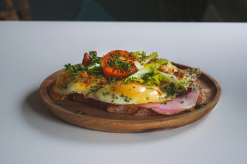 Delicious sandwich with ham, cheese, bacon, fried egg and tomato a typical Dutch lunch dish