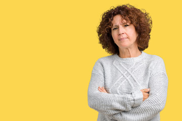 Beautiful middle ager senior woman wearing winter sweater over isolated background skeptic and nervous, disapproving expression on face with crossed arms. Negative person.