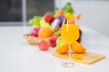 Orange juice is placed on a white table, orange juice, bright colors placed on the table and the atmosphere in the kitchen is clean white.