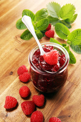 raspberry jam with fresh raspberries and mint. marmalade on spoon and jar