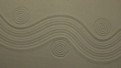 Unusual sand texture. Drawn waves and circles in the sand. With space. - Powered by Adobe
