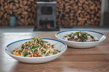 Delicious caesar salad and goatcheese salad on wooden table