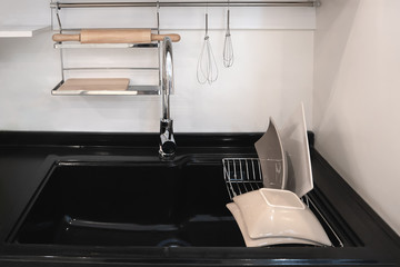 Black sink/The top view of the black marble kitchen sink stands on a white counter in a room with white walls.