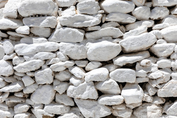 Background pattern of a white stone wall as seen on the cyclades islands of Greece