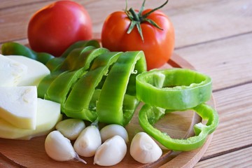 Sliced fresh vegetables on wooden background.