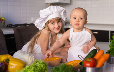  little girl and boy, white chef hat, vegetables