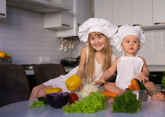  little girl and boy, white chef hat, vegetables