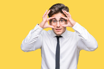Young business man wearing glasses over isolated background Trying to open eyes with fingers, sleepy and tired for morning fatigue