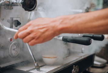 Cafe pouring from coffee machine. Professional coffee brewing