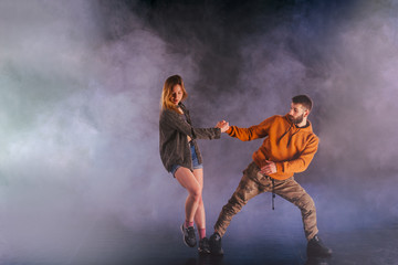 Fototapeta na wymiar Young couple dancing on the dark background