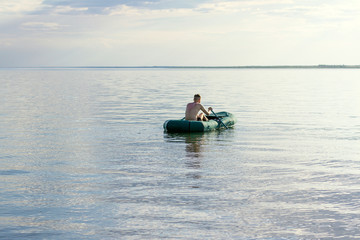 Fototapeta na wymiar young man sailing on a lake in a boat