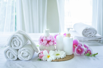 Obraz na płótnie Canvas Spa concept. Spa treatment set and aromatic massage oil on bed massage. Thai setting for aroma therapy and massage with flower on the bed, relax and healthy care.