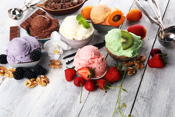 ice cream scoops of different colors and flavours with berries, nuts and fruits decoration on white background