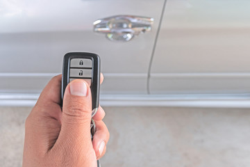 Hand of man holding and push remote control car,Hand of man holding and push remote control of car and white car parking background technology transportation safety concept