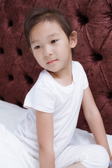 Chinese girls in white dresses sitting on the bed playing