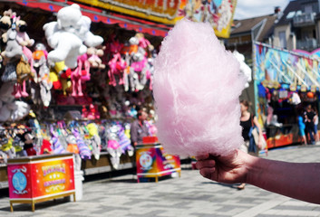 amusement park eating white cotton candy. enjoying a day at amusement park with fresh cotton candy in hand