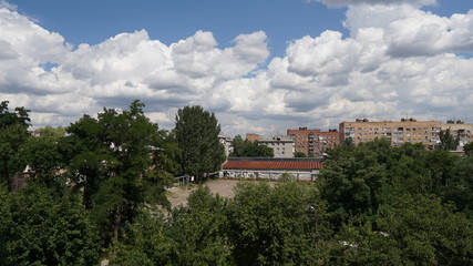 Fototapeta na wymiar View of the city with a clouds in a summer day over background
