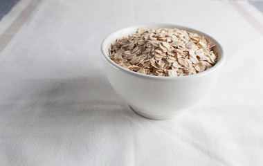 Oatmeal in a bowl on a tablecloth, top view.Copy space