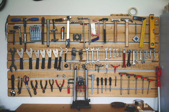 assortment of tools on a garage wall hanger