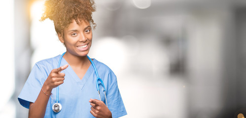 Young african american doctor woman over isolated background pointing fingers to camera with happy and funny face. Good energy and vibes.