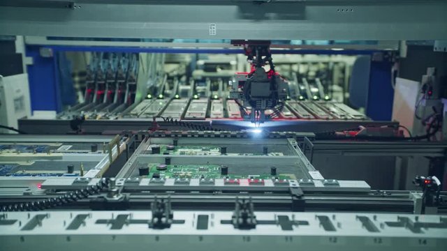Automated SMT machine placing electronic components on a board.