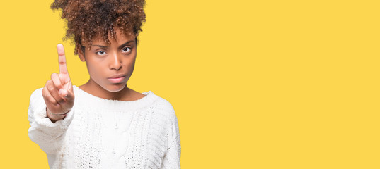 Beautiful young african american woman wearing winter sweater over isolated background Pointing...