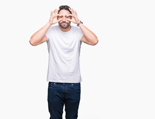 Fototapeta premium Handsome man wearing white t-shirt over white isolated background Trying to open eyes with fingers, sleepy and tired for morning fatigue