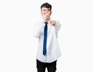 Young handsome business man wearing glasses over isolated background Laughing of you, pointing to the camera with finger hand over mouth, shame expression