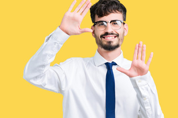 Young handsome business man wearing glasses over isolated background Smiling doing frame using hands palms and fingers, camera perspective