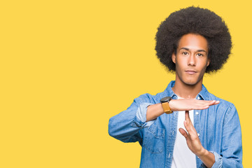 Young african american man with afro hair Doing time out gesture with hands, frustrated and serious...