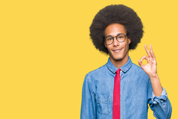 Young african american business man with afro hair wearing glasses and red tie smiling positive doing ok sign with hand and fingers. Successful expression.