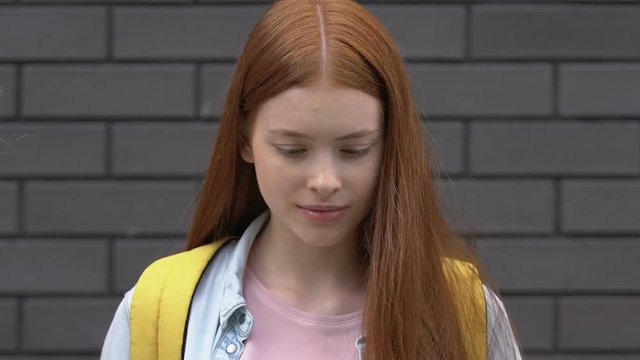 Mean schoolchildren teasing red hair girl about clothes, appearance bullying