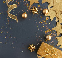 christmas or new year frame decorations in gold colors on dark blue background with empty copy space for text. holiday and celebration concept for postcard or invitation. top view 