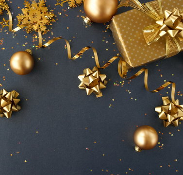 christmas or new year frame decorations in gold colors on dark blue background with empty copy space for text. holiday and celebration concept for postcard or invitation. top view 