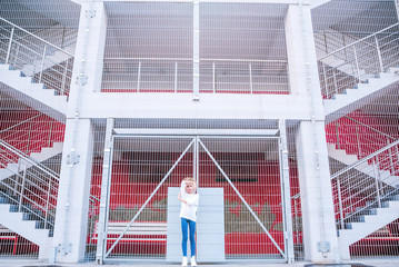fashionable teen girl posing against a background of a building and lattice