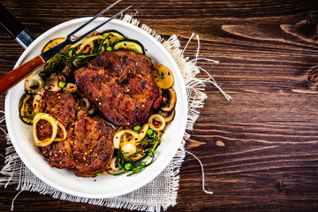 Grilled steak, baked potatoes and vegetables